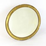 A 19thC oval giltwood and gesso wall mirror with bevelled glass. The surround having moulded and