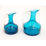 Two Whitefriars glass jugs with turquoise / kingfisher blue bodies and clear glass handles. The