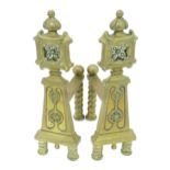 A pair of Arts & Crafts cast brass fire dogs with rosette decoration and twist detail to supports.
