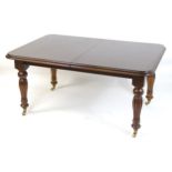 A late 20thC / early 21stC mahogany dining table with a moulded top and rounded corners above reeded