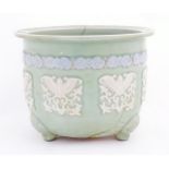 A Chinese jardiniere / planter standing on three feet with celadon style ground and banded bird