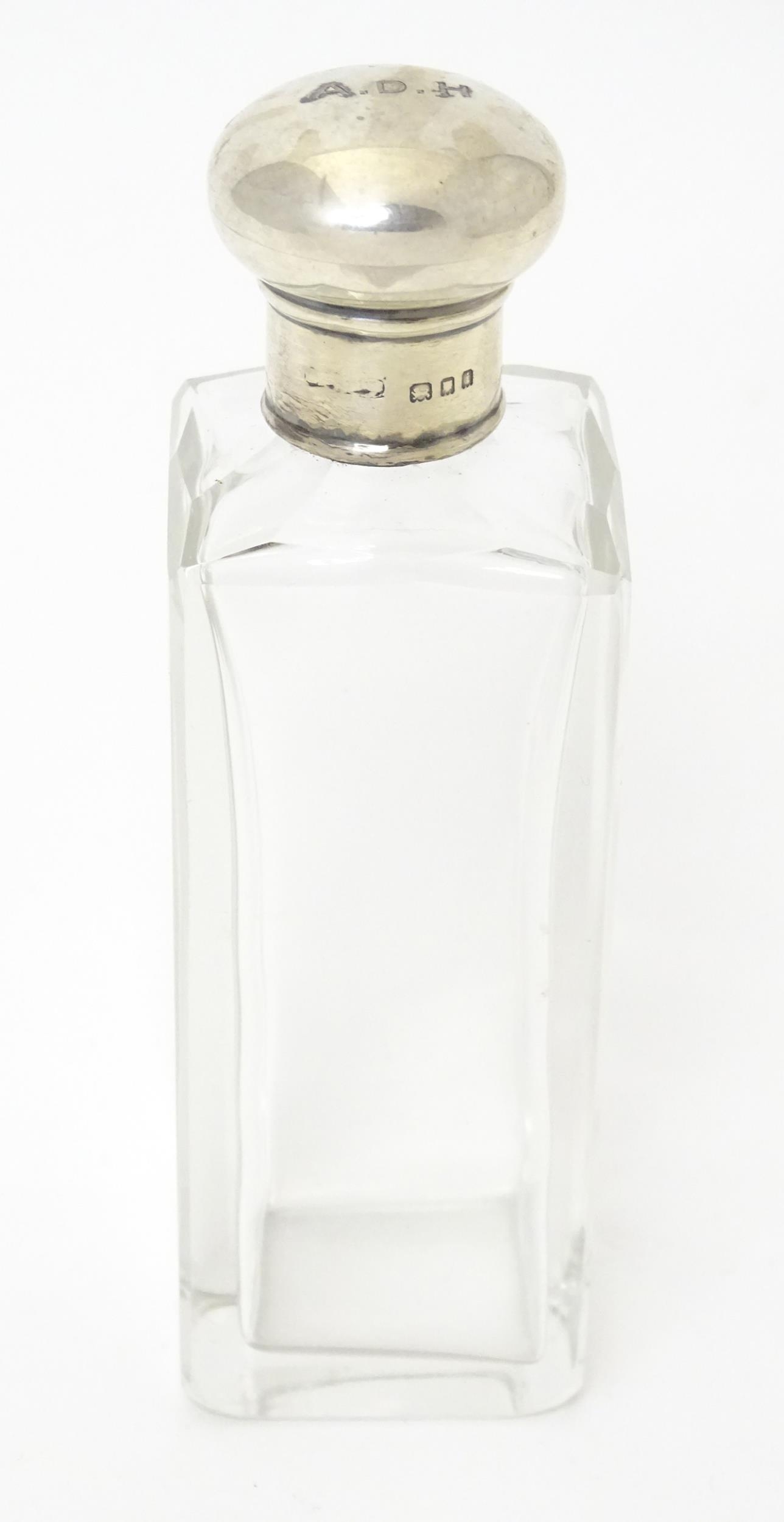 A glass dressing table jar of squared form with silver lid hallmarked London 1924. Approx. 5 1/4"