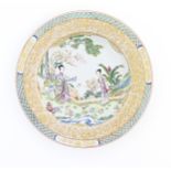 A Chinese / Cantonese plate decorated with a garden scene with two ladies holding fans, with