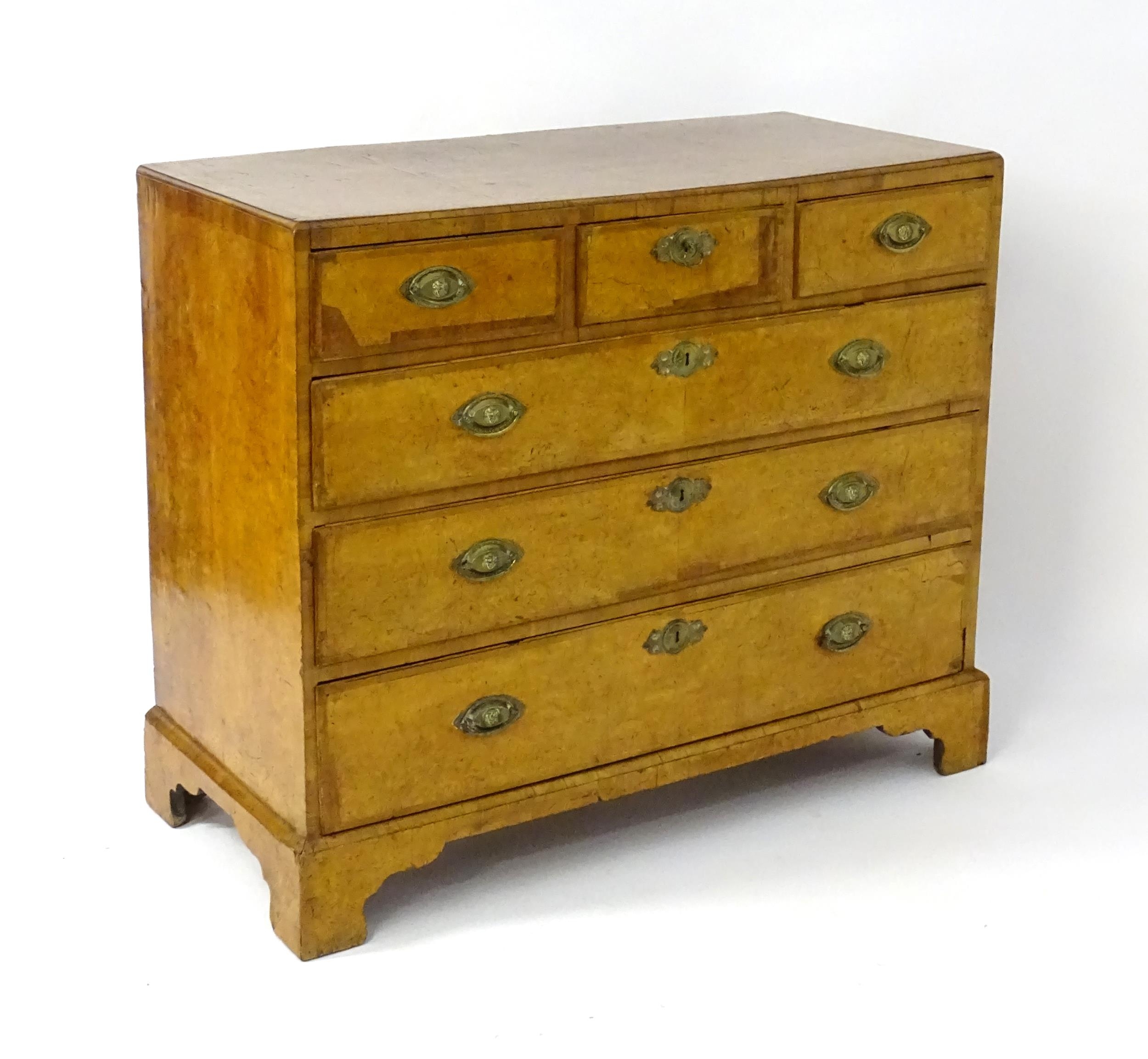 A George III walnut chest of drawers, the chest having a crossbanded top above three short over