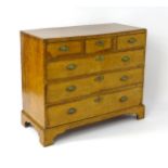 A George III walnut chest of drawers, the chest having a crossbanded top above three short over