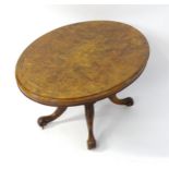 A late 19thC loo table with a burr walnut top inlaid with satinwood marquetry, the central carved