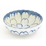 A Japanese blue and white bowl with floral decoration and petal brushwork detail. Character marks