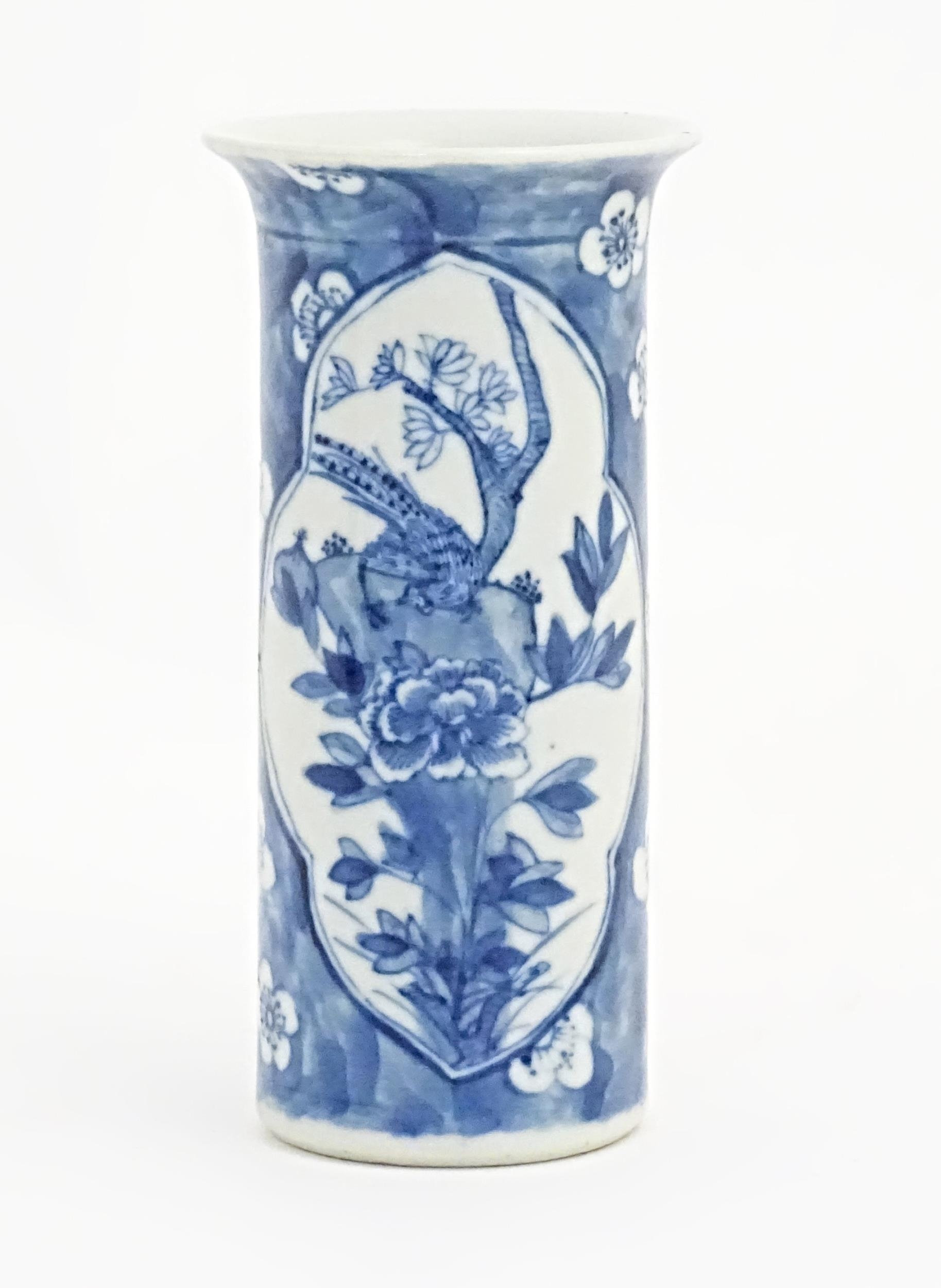 A Chinese blue and white vase of cylindrical form with a flared rim, decorated with birds, flowers