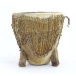 Ethnographic / Native / Tribal: An African animal hide drum raised on three legs. Approx. 14 1/4"