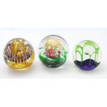 Three assorted paperweights to include an example by Langham glass designed by Paul Miller, together