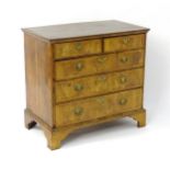A George II walnut chest of drawers, having a crossbanded top above two short over three long