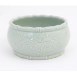 A Chinese celadon bowl decorated in relief with bats and peaches. Character marks under. Approx.