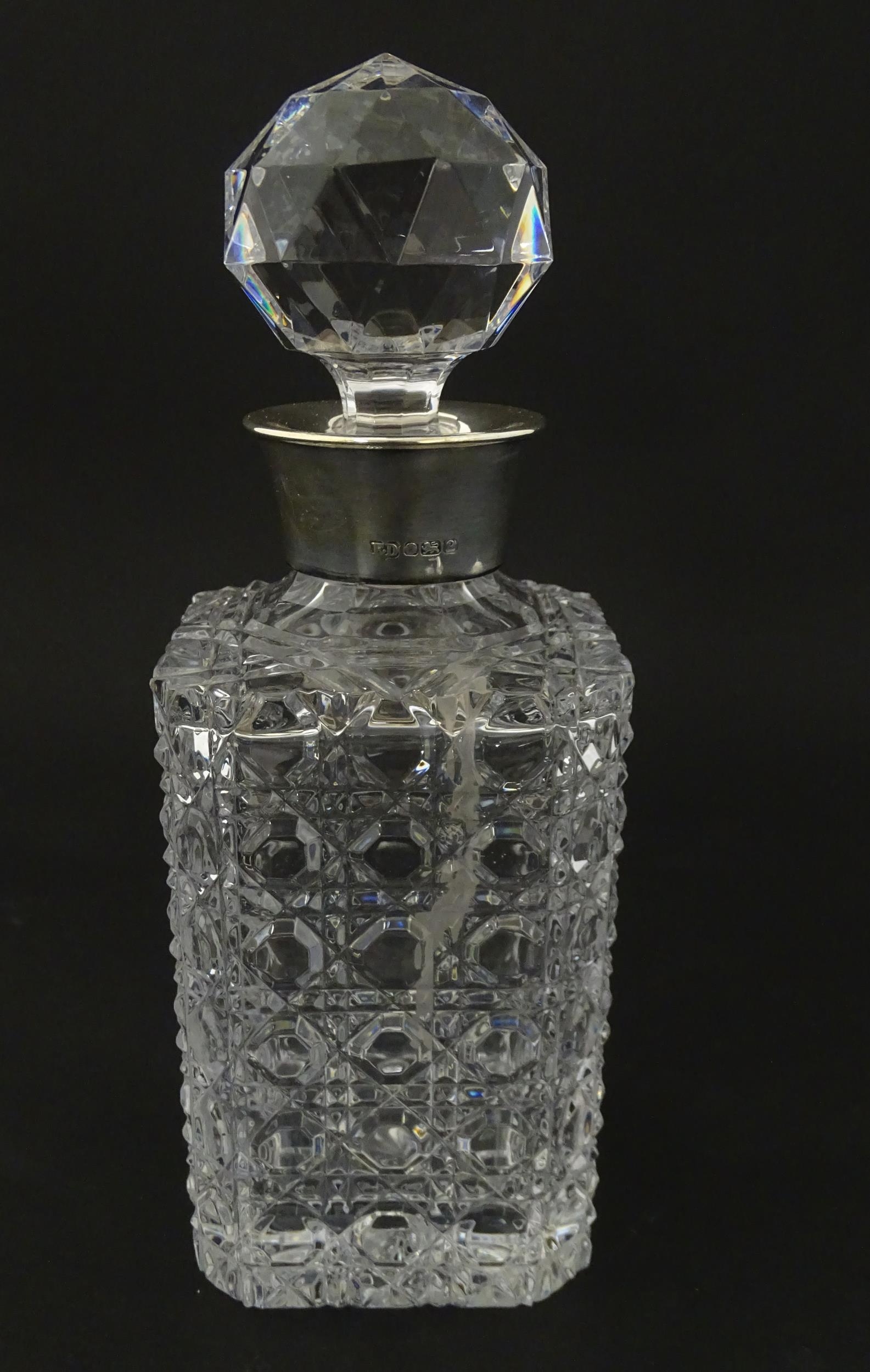 A cut glass decanter with silver collar hallmarked Sheffield 1989 maker F Drury Ltd. Approx 9 1/2"