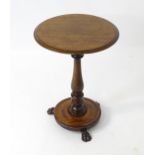 A late 18th / early 19thC mahogany circular topped table with a turned stem and dished base,