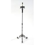 A 20thC wrought iron standard lamp, the scrolled triform base with partial twist column supporting a