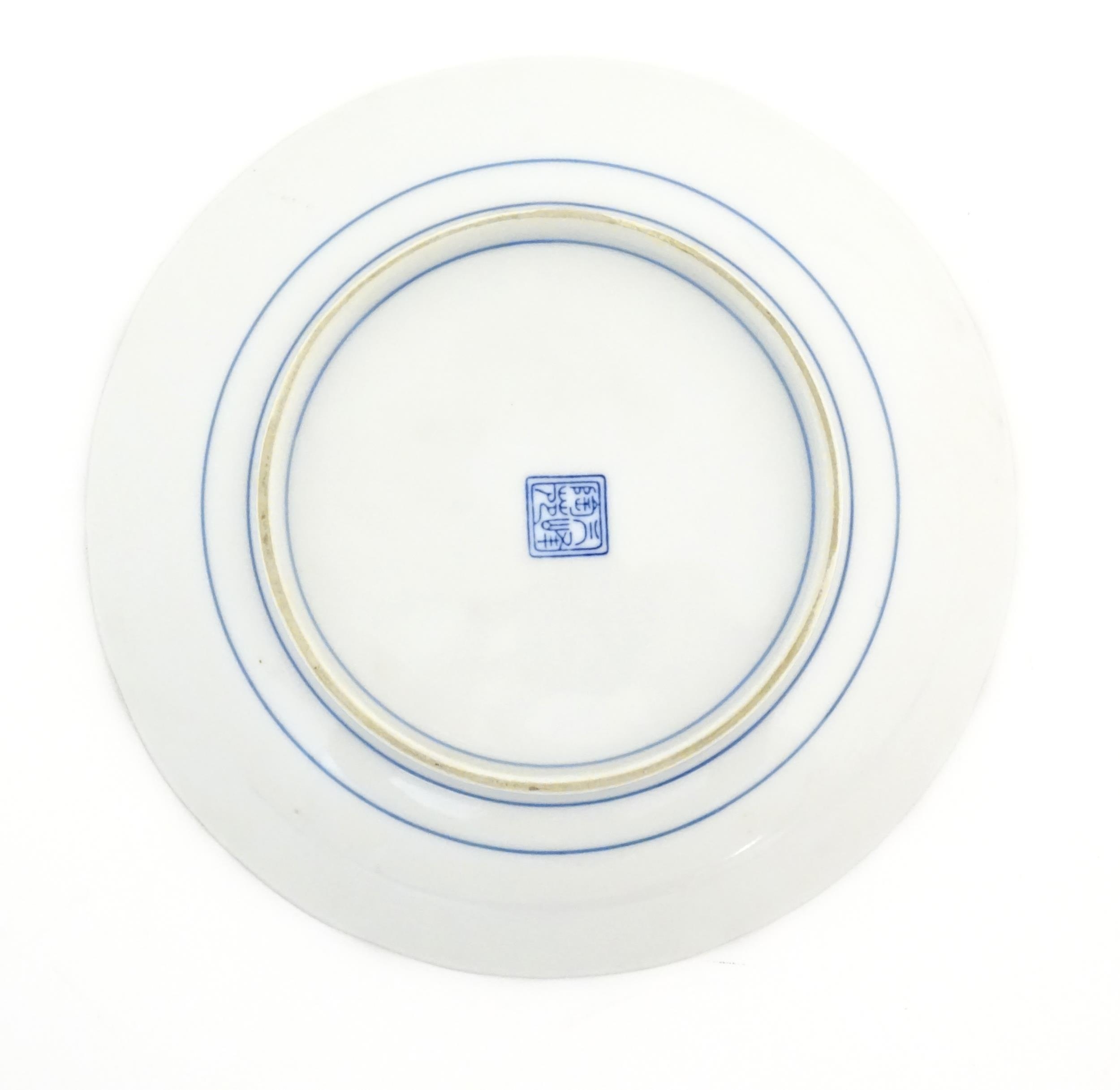 An Oriental blue and white plate with pink and green highlights depicting flowers. Character marks - Image 3 of 3