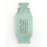 A Chinese wall pocket of vase form decorated with character script and relief foliate detail.