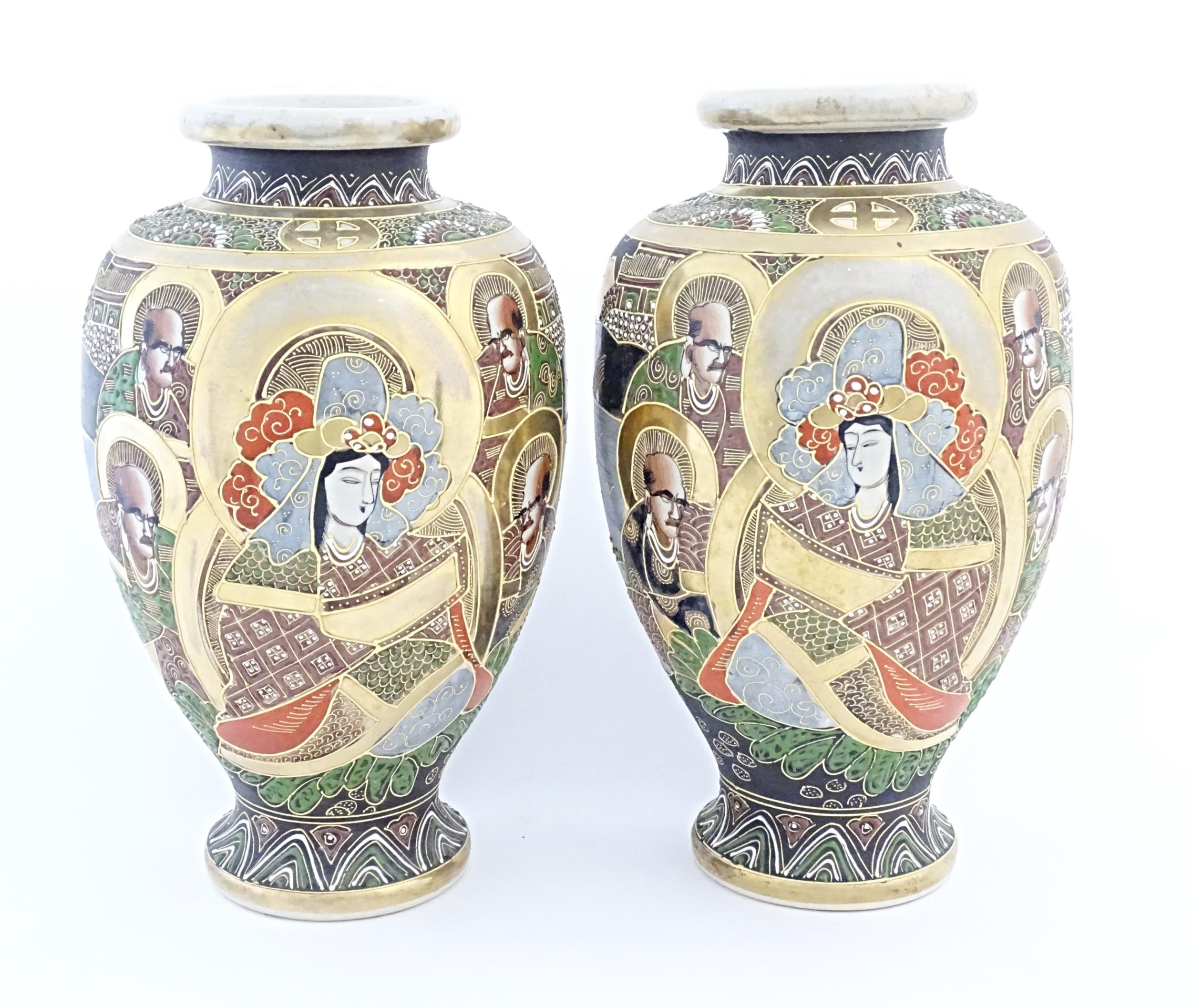 A pair of Japanese Satsuma vases of baluster form decorated with a central female figure bordered by