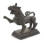 An Oriental cast temple lion with scrolled tail on a pierced rectangular base. Approx. 7 1/2" high