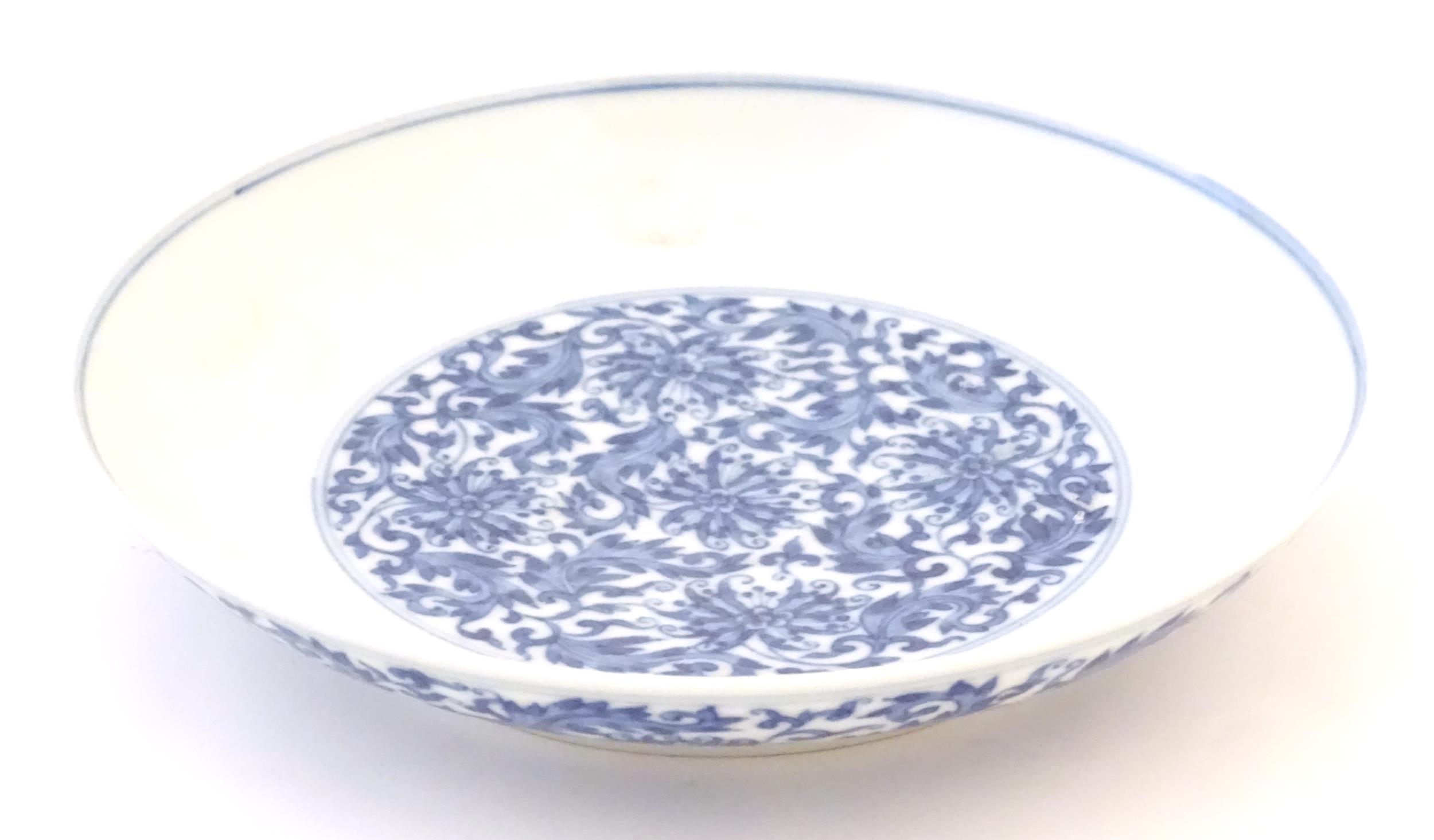 A Chinese blue and white plate decorated with scrolling floral and foliate detail. Character marks - Image 4 of 5