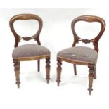 A pair balloon back dining chairs with carved mid rails and raised on reeded tapering front legs