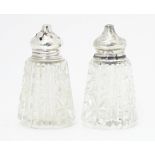 A pair of glass salt and pepper pots with silver lids hallmarked London 1922. Approx. 2 3/4" high (