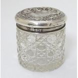A cut glass dressing table pot with silver top hallmarked Birmingham 1921 maker A J Pepper & Co.
