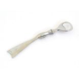 A boxed silver plated bottle opener, the handle formed as a the stock and action of a shotgun,
