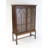 A late Georgian mahogany cabinet with a moulded cornice above two astragal glazed doors with