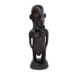 Ethnographic / Native / Tribal: An African carved hardwood figure with inlaid eyes and carved