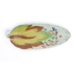A Clarice Cliff Newport pottery plate of leaf form with painted floral and foliate decoration.