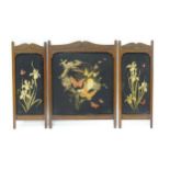 A carved oak fire screen in three sections, with embroidered floral detail Please Note - we do not