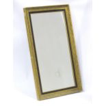 A 20thC rectangular mirror, with gilt wood frame and black painted border, measuring 45 1/2" x 26"