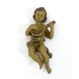 A carved putto playing a lute. Approx. 9" long Please Note - we do not make reference to the