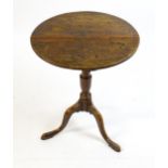 A late 18thC oak tripod table with a circular top above a tapering turned pedestal and three
