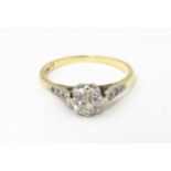 An 18ct gold ring with platinum set central diamond flaked by three further diamonds to each