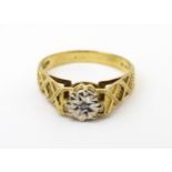 A 9ct gold ring set with an illusion set diamond with engraved detail to shoulders. Ring size