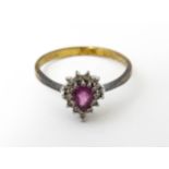 A yellow metal ring set with pink sapphire flanked by diamonds. Ring size approx. M Please Note - we