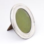 An easel back photograph frame of oval form with a silver surround hallmarked Birmingham 1919