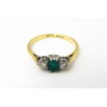An 18ct gold ring set with central emerald flanked by diamonds. Ring size approx. L Please Note - we