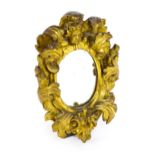 An early 18thC gilt mirror with floral and foliate mouldings surrounding a cherub mask. 14" wide x