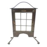 An Arts & Crafts fire screen with embossed foliate copper surround and nine glass panels to