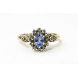 A 9ct gold ring set with central topaz bordered by diamonds flanked by further diamonds to