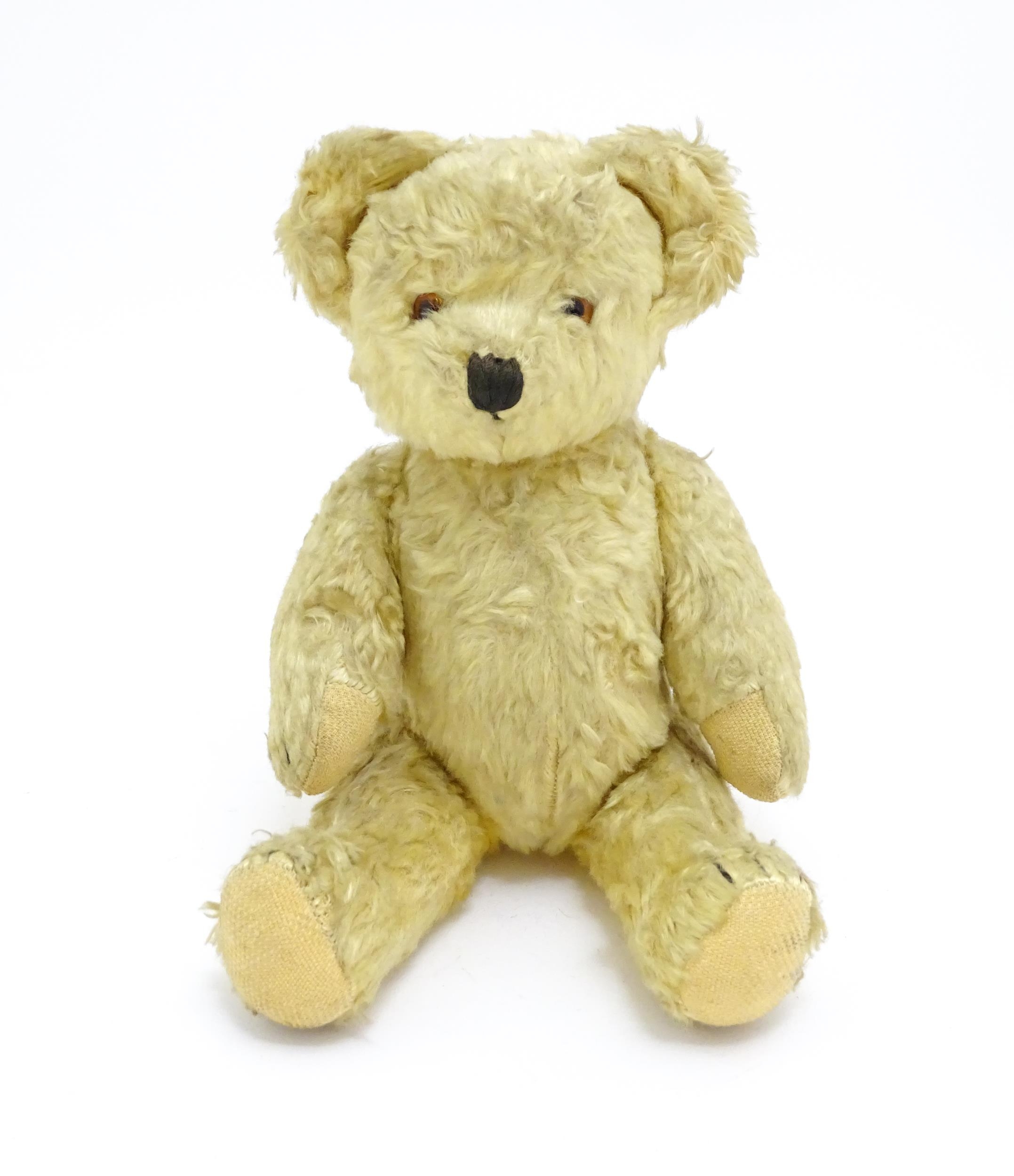 Toy: A 20thC straw filled teddy bear with stitched nose, mouth, and claws, pad paws and