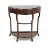 A late 19thC / early 20thC Qing dynasty demi lune table, with a carved front, a frieze drawer and