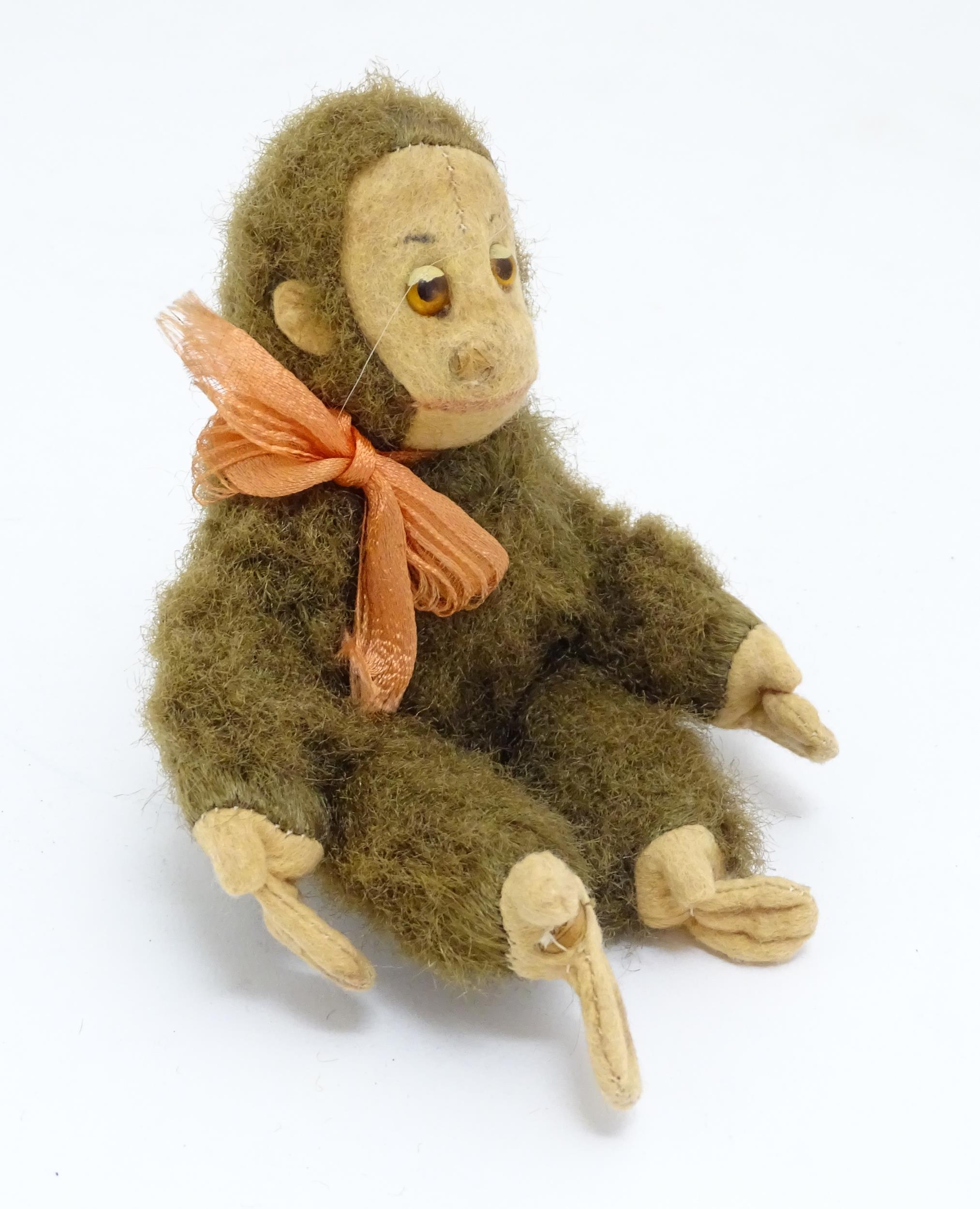 Toy: A small 20thC straw filled soft toy modelled as a monkey / chimpanzee with felt face, ears