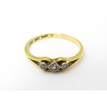 An 18ct gold ring with platinum set central diamond flanked by two further diamonds. Ring size