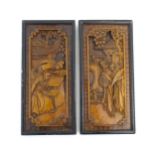 Two Oriental carved wooden panels, one depicting figures with fans in a garden, the other