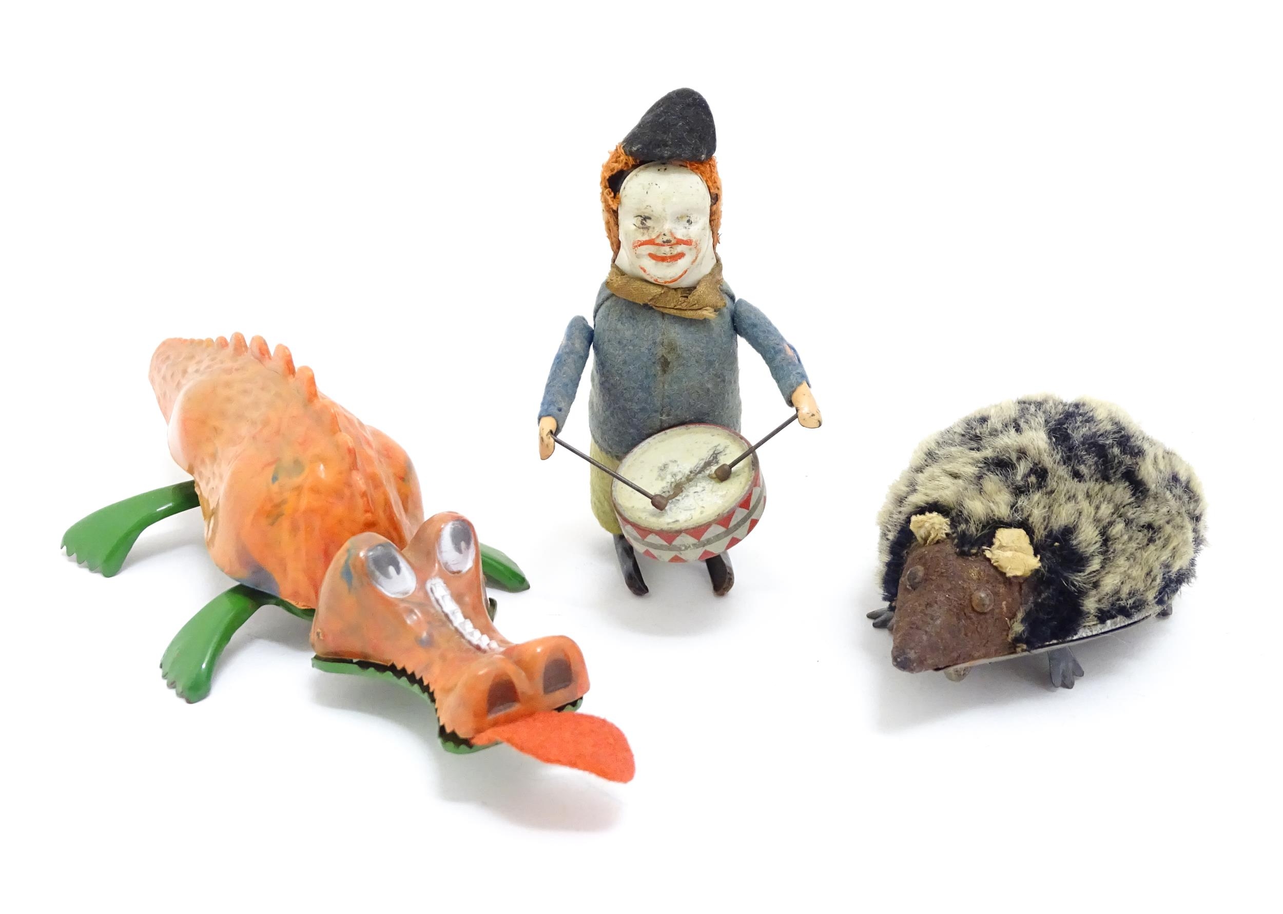Toys: Three 20thC clockwork / wind up toys comprising a Schuco model of a clown playing the drum,