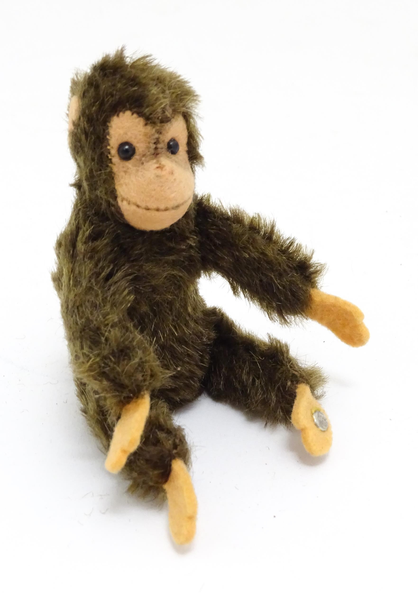 Toy: A small 20thC Steiff mohair soft toy modelled as a monkey / chimpanzee, with felt face, ears